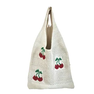 Stylish cream white knit tote bag featuring a vibrant red cherry pattern and woven texture