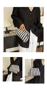 Pochette nuage chic à rayures bleues et blanches tenue par un mannequin dans un décor