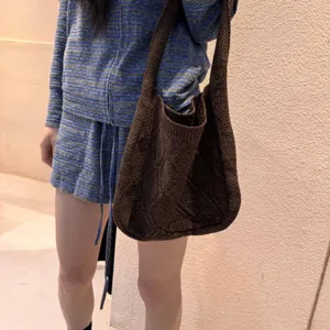 Detailed view of a vintage brown cable knit tote bag styled as a shoulder bag for women