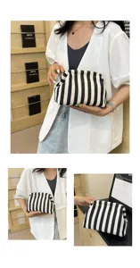 Pochette nuage tendance à rayures noires et blanches tenue par un mannequin élégant