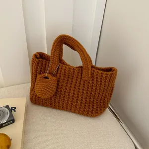 Retro handmade brown crochet handbag with intricate knit pattern and small charm