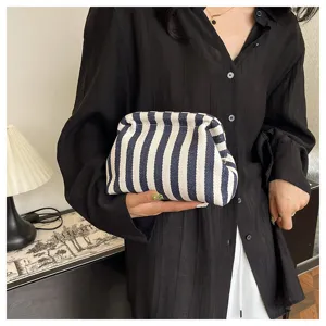 Détail d'une pochette nuage à rayures bleues et blanches à la mode tenue par un mannequin