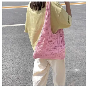 Vue lifestyle d'un sac à bandoulière en maille rose ajourée porté dans un cadre extérieur