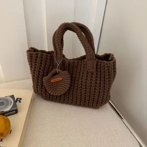 Close-up showing the rich texture of a brown handmade crocheted handbag with a mini pouch.