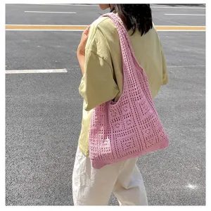 Vue détaillée d'un sac cabas rose en maille tricotée porté à l'épaule en extérieur