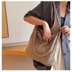 Gros plan d'un sac à bandoulière rétro en maille tricotée ajourée porté par un mannequin