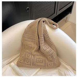 Gros plan d'un sac à bandoulière en crochet beige à mailles ajourées rétro.