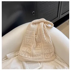 Vue détaillée du motif ajouré en maille crème sur ce sac à bandoulière tissé.