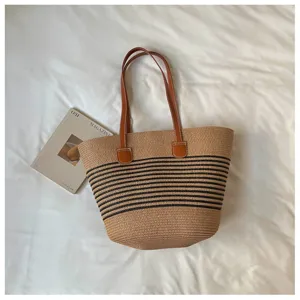 Large natural straw woven tote bag with black stripes for summer beach vacation look