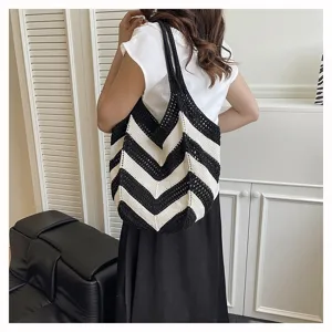 Large capacity woven shoulder bag with black and white stripes shown on a model's shoulder