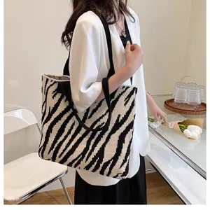 Zebra pattern knit shoulder bag shown on model in a stylish indoor setting