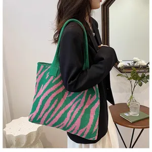 Detailed side view of a large zebra-patterned green and pink knitted tote bag