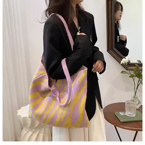 Large capacity zebra pattern knit tote bag in purple and yellow colors carried by a model
