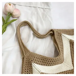 Close-up of handcrafted beige and white crochet knit tote bag with chevron pattern detail