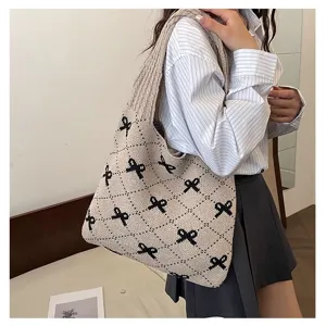 Close-up of a knitted tote bag with a stylish black bow pattern over the shoulder