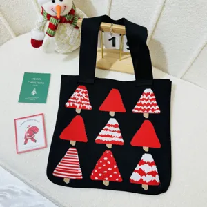 Close-up of a festive black knitted tote bag featuring red and white Christmas tree patterns