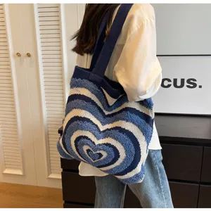 Detailed view of women knitted shoulder bag, blue white heart pattern large capacity tote.