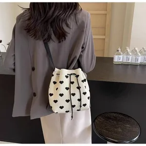 Back view of a chic knitted bucket bag with black heart patterns on white fabric