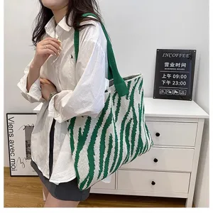 Stylish zebra pattern knitted tote bag carried by a model in a modern interior setting