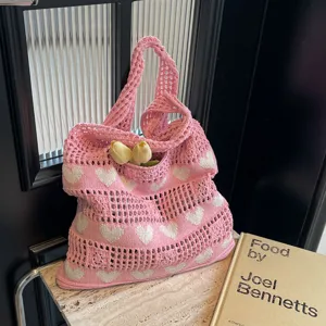 Close-up of a pink heart pattern hollow knit tote bag featuring decorative tulips