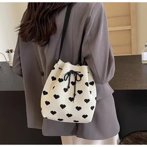 View showing the black heart pattern and drawstring closure of the white knitted bag