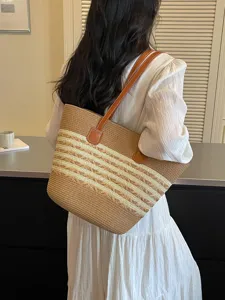 Large straw woven tote bag with horizontal stripes, perfect for summer beach travel.