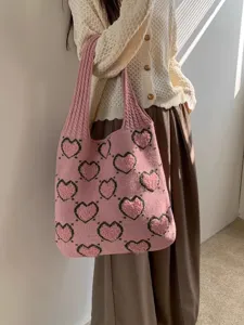 Primo piano della borsa tote rosa lavorata a maglia con cuori per un look casual