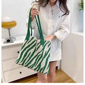Detailed view of a stylish green zebra pattern knit tote bag held by a model in a room