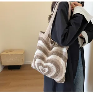 Close-up detail of the cozy knitted shoulder bag featuring a stylish brown and cream heart pattern.