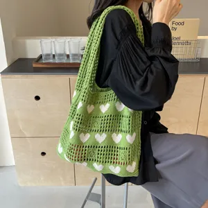 Macro detail of the green knitted heart tote bag showing the texture and openwork