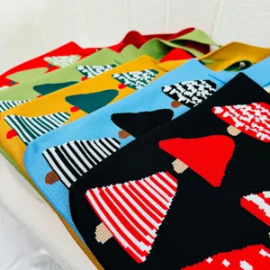 Detailed macro view of multi-colored knitted tote bags with festive Christmas tree patterns