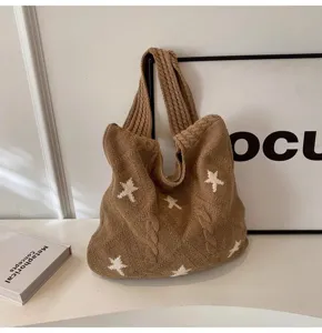 Macro view of brown knitted tote bag with white star pattern and cable texture