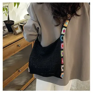 Bohemian black crochet bag with colorful floral strap shown on model