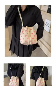 Close-up views showing different angles of cream drawstring bucket bag with pink heart patterns