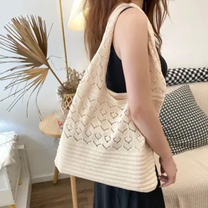 Vista detallada de un bolso de hombro de punto calado beige vintage en una modelo