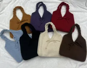 Detailed view showing various colors of handmade knitted bow handbags for autumn