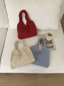 Charming knitted tote bags with bow accents in red, cream, and soft blue tones.