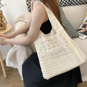 Detalle de estilo de vida de un bolso tote retro beige de punto tejido a mano para mujer.