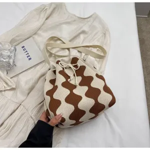 Detailed texture of the knitted wave pattern on this stylish drawstring crossbody bag