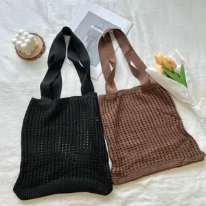 Close-up of black and brown knitted hollow mesh tote bags on a white textured background
