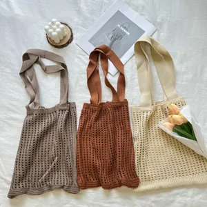 Detail view of colorful knitted hollow woven tote bags on a rustic aesthetic background