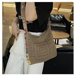 Detail view of bohemian crochet shoulder bag with colorful floral strap worn by model