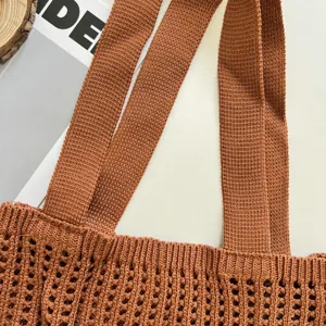 Close-up detail of a terracotta knitted hollow tote bag showing crochet texture.