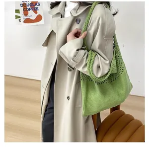 Detalle de un bolso tote de punto calado verde con un diseño de rombos elegante