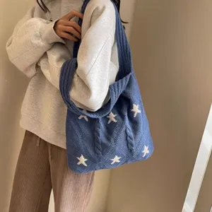 Blue knitted tote bag with white star pattern and cable knit texture for women