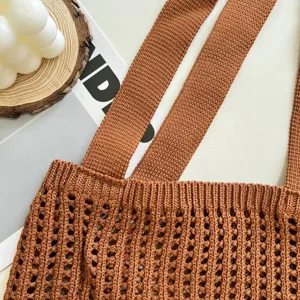 Close-up detail of brown hollow-out knitted tote bag showing texture and straps