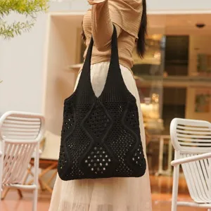Vista lateral de un elegante bolso tote de punto calado negro llevado por una modelo