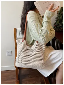 Lifestyle view of a beige hollow woven beach bag with brown leather shoulder straps