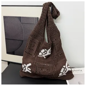 Detailweergave van een bruine gehaakte shopper met witte gebreide bloemenpatronen