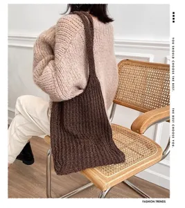 Detailed texture of the large capacity brown knitted tote bag on a model